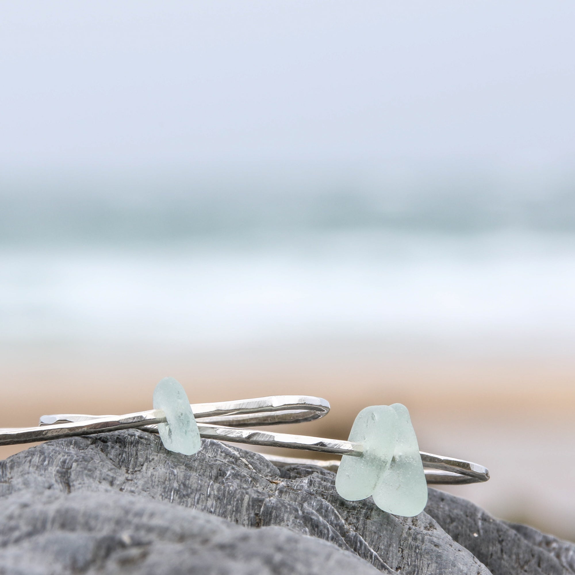 Follow the Tides - A handmade hammered recycled sterling silver 925 bangle decorated with a beautifully unique piece of seafoam coloured sea glass collected from the North Devon coast.