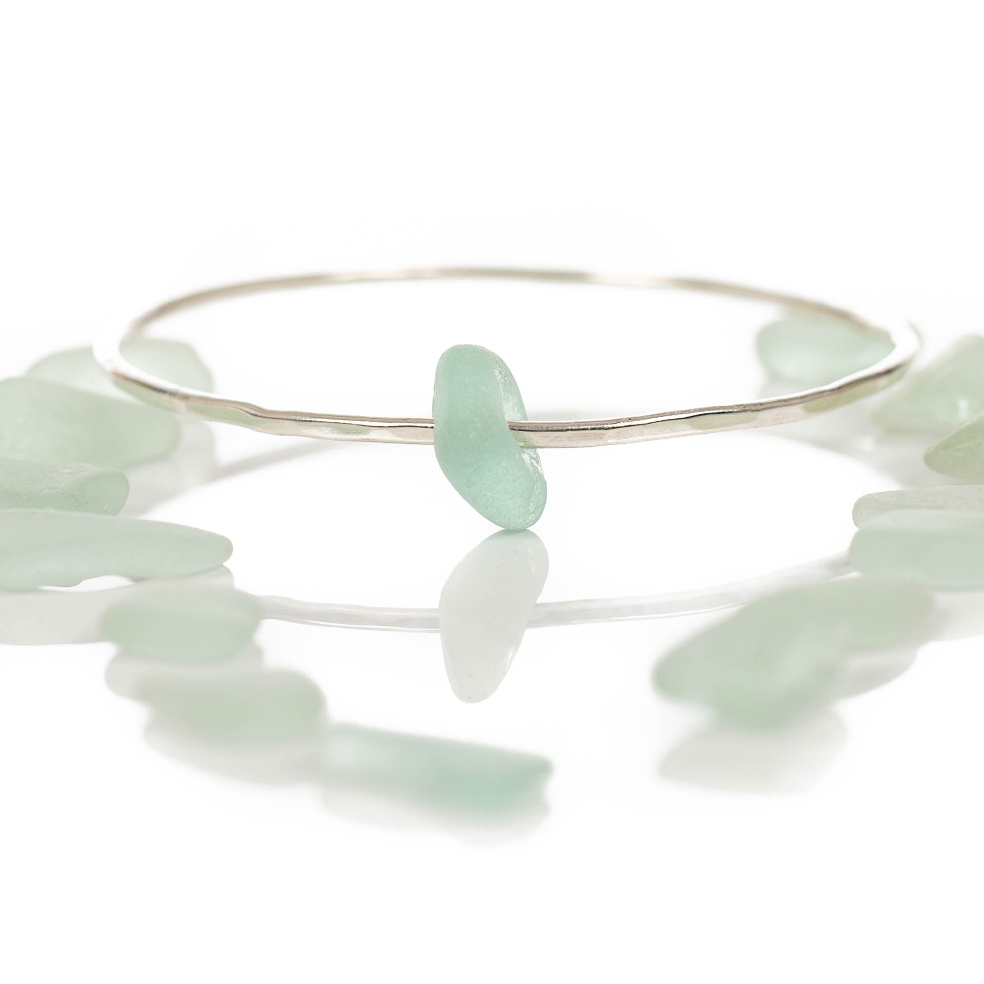 Follow the Tides - A handmade hammered recycled sterling silver 925 bangle decorated with a beautifully unique piece of seafoam coloured sea glass collected from the North Devon coast.